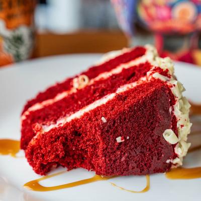 A slice of red velvet cake on a white plate.