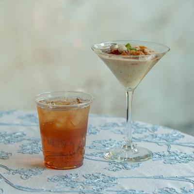 Shrimp and Grits in a martini glass and a glass of refreshing drink.