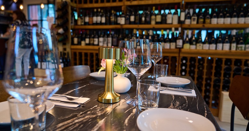 Diner set up table, wine rack behind