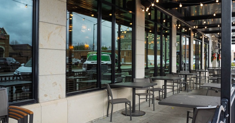 Exterior, patio, covered seating area, tables for two, entrance, concrete flooring