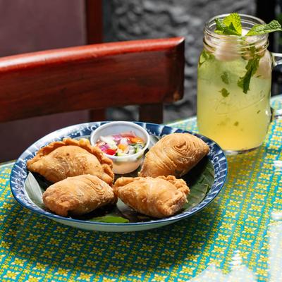 Chicken Curry Puffs on a table with a lychee-mint lemonade.