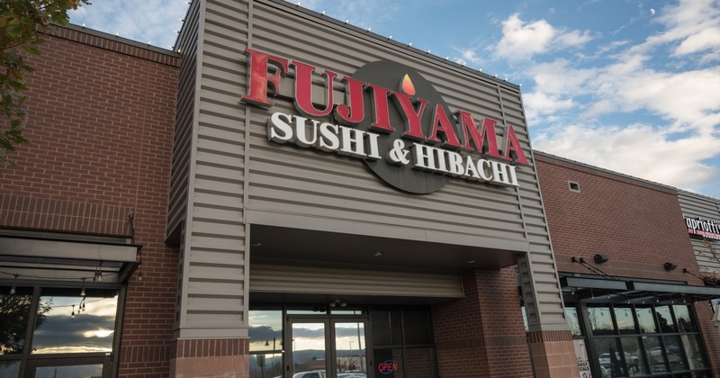 Exterior, low angle view to restaurant front, entrance, sign above