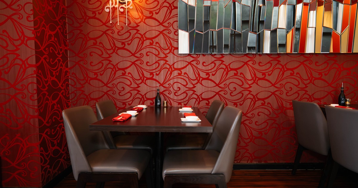 Dining table setup with wall art and red patterned wallpaper