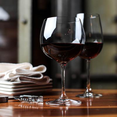 Two glasses of red wine served on the table.