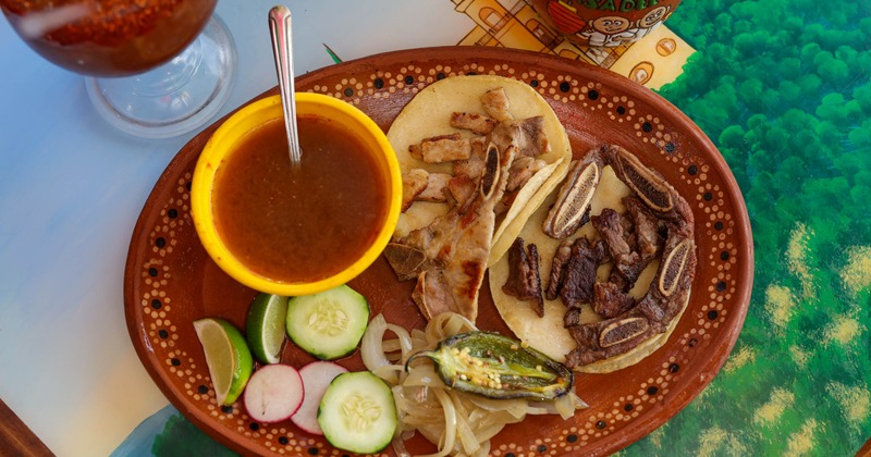 Taco dish with side of vegetables and dipp