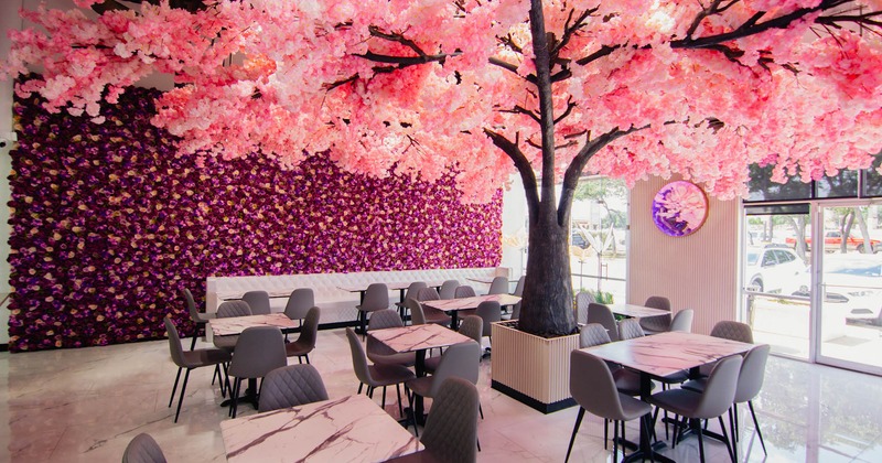 Interior, dining area, tables with chairs, cherry blossom tree as a room centerpiece