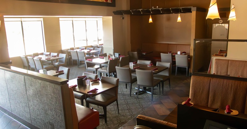 Interior, dining area, wooden top tables for four, banquette bench with tables, carpet flooring