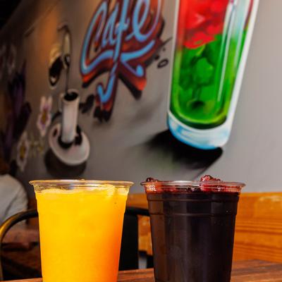 Two mixed juices served in clear cups on a dining table.