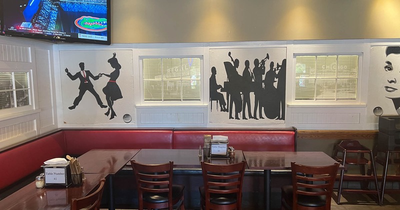 Interior, seating and tables, mural art and a TV