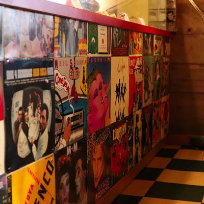 A wall adorned with colorful vinyl record covers.