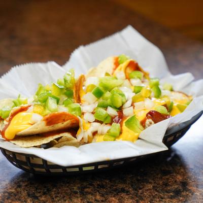 Nachos with chili, cheese, onions, and green peppers.