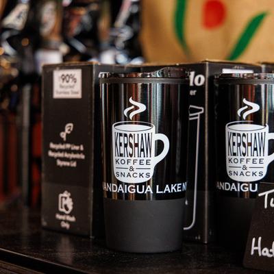 Branded black travel tumblers  displayed on a counter, close-up.
