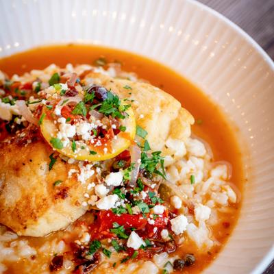 Haddock filet with Parmesan risotto, tomato sauce, herbs, and feta cheese.
