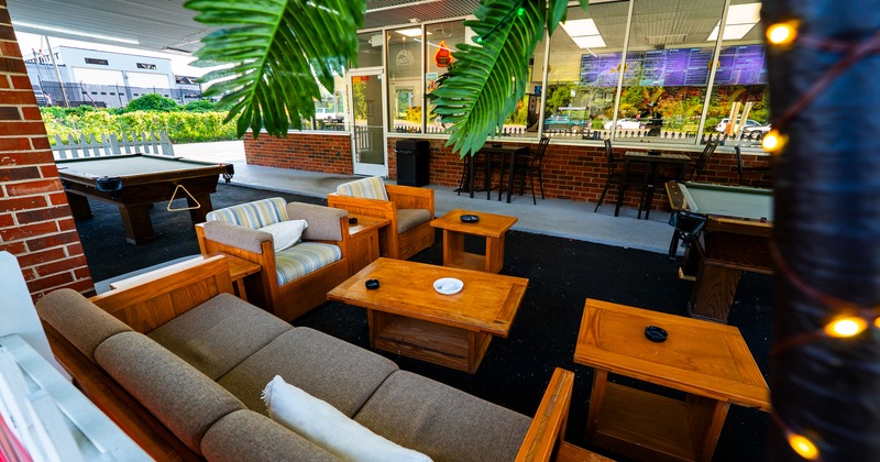 Terrace, seating cool place, couch, armchairs, coffee table, bar behind