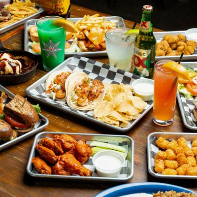 Various trays of food served on the table with drinks.