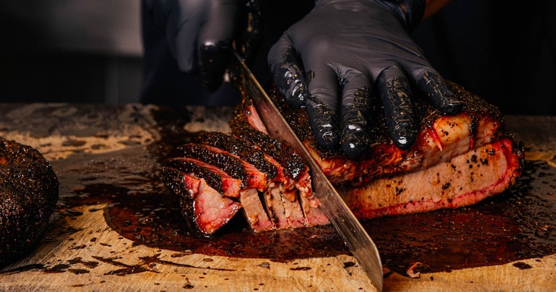 An employee slicing brisket