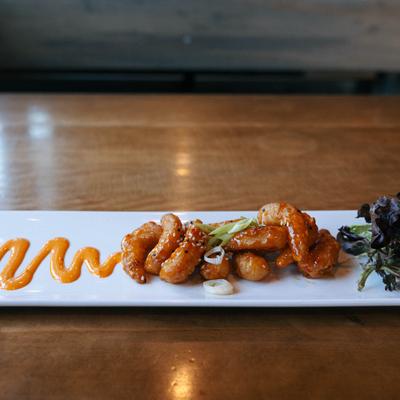 Crispy fried shrimp appetizer with sweet chili orange sauce and mixed greens.