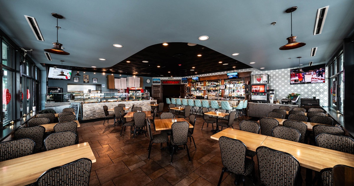 Interior, dining area, tables with chairs ready for guests, bar and soda fountain in the back