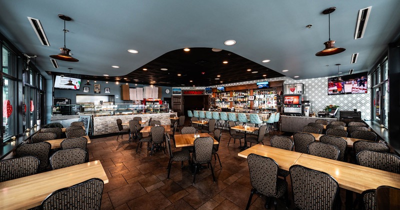 Interior, dining area, tables with chairs ready for guests, bar and soda fountain in the back