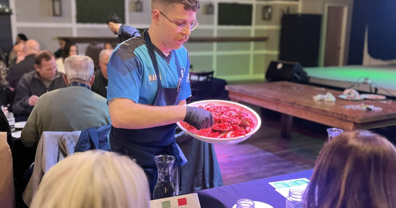 A server serves food at a table