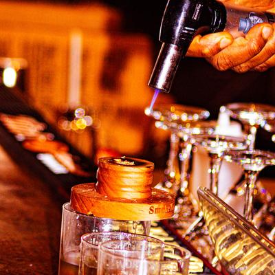 Bartender smoking a cocktail.