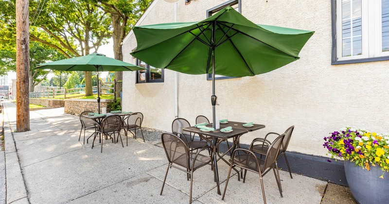 Patio, two tables with tableware, seats and parasols