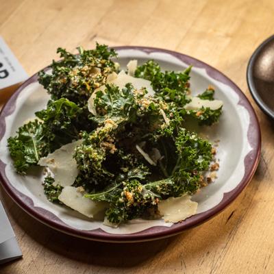Kale Caesar topped with shaved Parmesan.