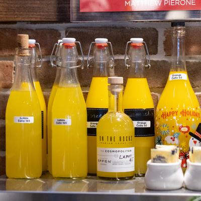 Numereus bottles of homemade Limoncello on the counter.