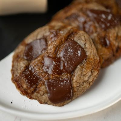 Chocolate chip cookie served on a white plate, close-up.