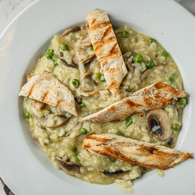 Risotto Parmigiano with chicken, pees, and mushrooms, top view.