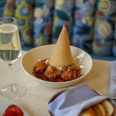 Fried chicken with a waffle cone, served with a glass of sparkling wine.