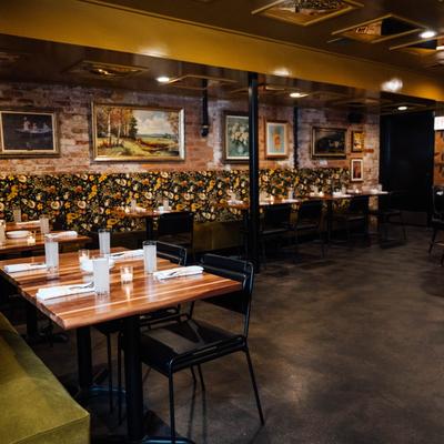 Dinning area, banquette seating, set tables, partial view of bar seating