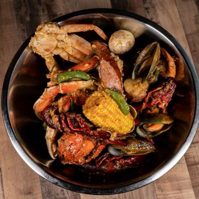 Cajun seafood boil featuring a variety of ingredients served in a metal bowl.