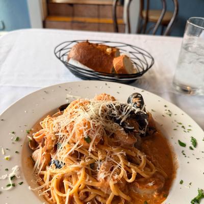 Seafood pasta with grated cheese and bread.
