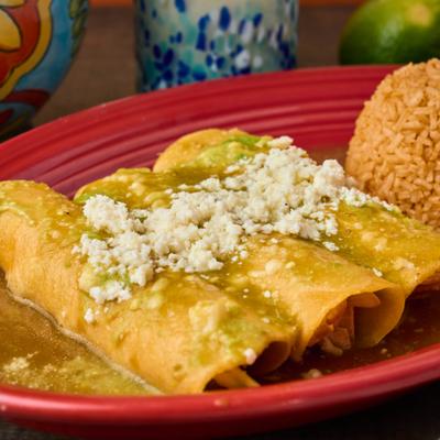 Enchiladas with green salsa, fresh cheese, and rice.