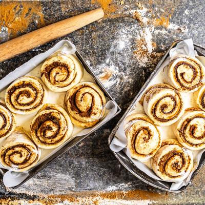 Unbaked cinnamon rolls in baking pans.