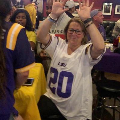 A fan girl in a white and purple jersey