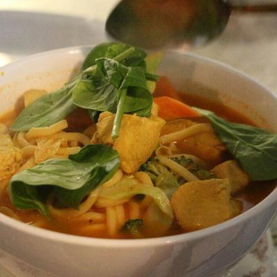 Chicken Vegetables noodle dish with spinach leaves on top