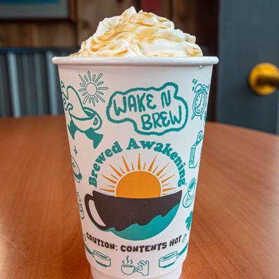 Hot drink topped with whipped cream in cup.