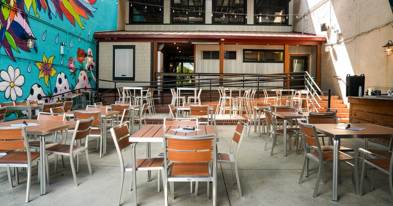Outdoor patio dining area with empty tables and chairs