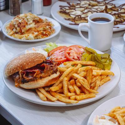 Texas Burger plate with other dishes and a mug of coffee.