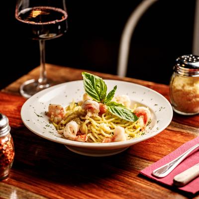 Garlic shrimp pasta plate served with red wine.
