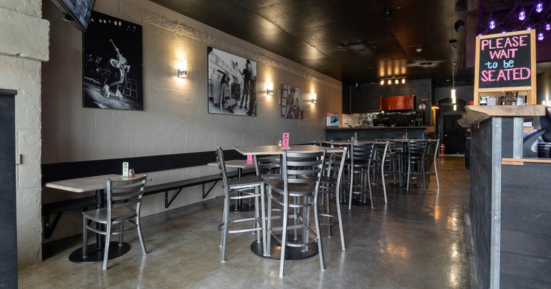 Interior, tables with chairs and banquette seating along the wall
