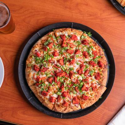 Whole Tandoori Chicken Pizza, plated and served.