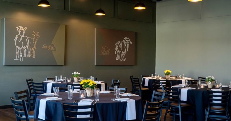 Interior, round tables set for guests in dining area