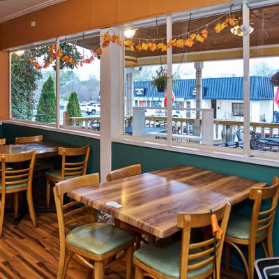 Wooden tables and chairs by the windows.
