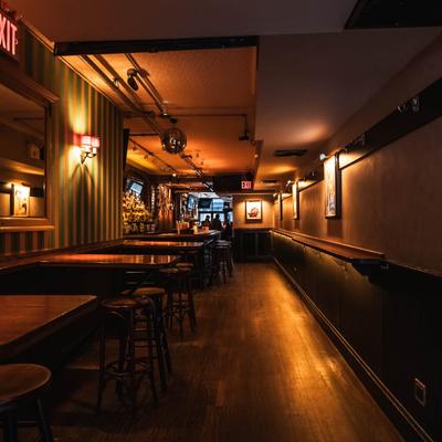 Interior, high tables and chairs with bar in the back.