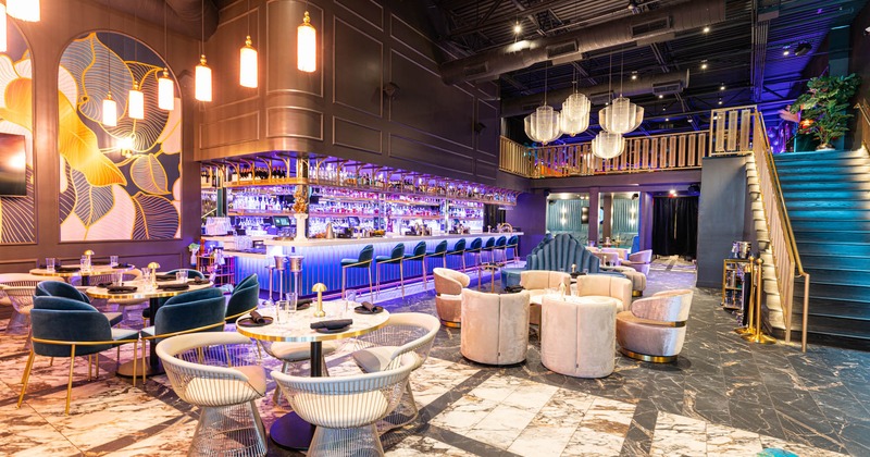 Interior, upholstered chairs, tables, counter, lighting, staircase