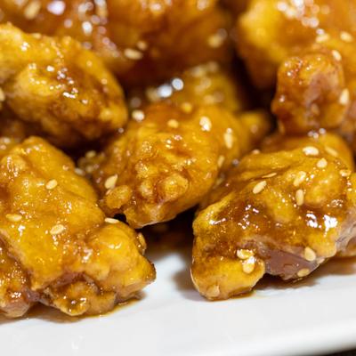 Close-up of glazed chicken pieces with sesame seeds.