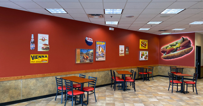 Interior, tables set for four next to decorated wall